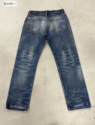 Klasyczne ciemno myte dżinsy z wąsaczami i zgaszającymi się w stylu vintage